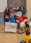 Lael Oldmixon, left, director of the UA College Savings Plan and Dash the mascot present 6-year-old Peyton Livingston and his family with a $25,000 scholarship account award. Submitted photo