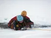 "Victim" Dan Bush hangs on to a rope as Doug Ferrett helps him
out of a hole during the Mat-Su Dive and Rescue Team's practice
session. Photo by STEVE KADEL/Frontiersman.