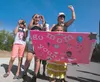 Faith Salima holds a sign for her mom as family and friends cheer her on at the finish of Saturday’s Why Not Tri triathlon at Wasilla High School. ROBERT DeBERRY/Frontiersman.com