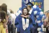 A pair of Palmer High School graduates enter their ceremony with
one carrying the other. The 2011 graduating class totaled 145
students. (ROBERT DeBERRY/Frontiersman)