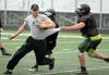 Colony assistant coach and offensive coordinator Matt Jaronik runs through a drill with his players during a team practice session on the second day of the 26th annual All-Alaska Football Cam