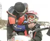 ROBERT DeBERRY/Frontiersman Tony Molesky adjusts the straps on
his son’s helmet before the start of the 120 modified class
snowcross race Saturday at the Ak Racing Motopark. Aaron, 10, along
