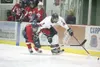 ROBERT DeBERRY/Frotiersman Houston Hawk Zach Lovelace keeps a
North Pole Patriot at bay as he takes the puck during Thursday'€™s
game at the Curtis C. Menard II Memorial Ice Arena in Wasilla.