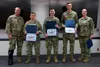 JOINT BASE ELMENDORF-RICHARDSON, Alaska -- Lt. Col. Travis Lytton (far left), 703rd Aircraft Maintenance Squadron commander, and Lt. Col. Mary Hosea (far right), 176th Aircraft Maintenance Sq
