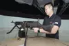 Min Chong, Mission Training Complex computer-based training instructor/specialist, explains how the simulated machine gun operates in a convoy simulation room at the MTC on Joint Base Elmendo