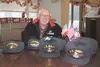 Bill Hutchins, a former U.S. Marine, displays baseball caps emblazoned with branch and theater of operations designations for World War II veterans at the Alaska Veterans and Pioneers Home in