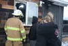 Cozy Cup Espresso owner Emma Doran hugs one of her baristas as a firefighter surveys the damage after a fire at the coffee stand Saturday. Jacob Mann/Frontiersman