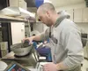 USDA biological science technician Rob Carter pours seeds into a
seed counter Thursday afternoon at the Arctic research studies
laboratory at the UAF Experiment Farm. (ROBERT
DeBERRY/Frontier