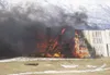 Firefighters responded to find the blaze, left, spewing thick,
dark smoke into the air. The fire reportedly started when staff at
the ranch were heating up some feed for their pigs. No injuri