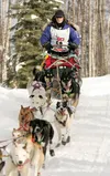 Bend, Ore., musher Rachael Scdoris heads out of the woods and
onto Crystal Lake during Sunday's Iditarod restart. Scdoris is
legally blind and is running the race with the help of Tim Osmar.
