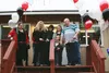 Knik House Director Andrea Moore performs the customary ribbon cutting ceremony with her husband and fellow board member, Lance, and other members of Blood N Fire Ministry to celebrate the gr