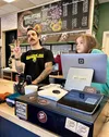 Alex Coker, owner of Cold Snap Coffee, takes an order while his daughter, Phoebe, 8, works the cash register. Coker is joining forces with Birdhouse Sandwich Co.’s Matthew Shaughnessy for a s