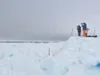 Photo courtesy of Ned Rozell Biologists Leslie Pierce and Craig
George search for migrating whales on an ice perch north of
Barrow.