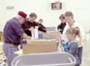 Maegan Grogan, 8, volunteers to pack Boxes for Heroes with her
grandparents, Linda and Bruce Berry. ‘Anything for our boys,’ Linda
said. In the background, Cadet Commander for the Civil Air P