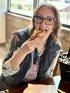 Juliah Barnett enjoys a slice of Buffalo Chicken pizza at House of Fire Pizza in Wasilla, which recently celebrated it's grand opening, the first for the pizza restaurant that has 3 locations