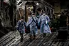 Three U.S. Air Force medical Airmen exit a C-17 Globemaster III aircraft following the first-ever operational use of the Transport Isolation System at Ramstein Air Base, Germany, April 10, 20