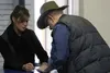 Nina Vignola hands a form to a customer Monday at the Settlers' Bay post office location. The new private facility opened at the location at 11 a.m., about a month after the abrupt closure of