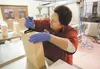 Matanuska Creamery employee Donna Wojcik trims the edge off a block of medium white cheddar cheese Thursday at the creamery’s Valley location off the Palmer-Wasilla Highway. The creamery anno
