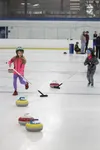 Siri Strabel and Hazel Adams sweep in front of culing stones during a curling event Sunday at the MTA Events Center in Palmer. Tim Rockey/Frontiersman