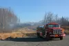 A fire truck stages at a gravel lot near Mile 56 of the Glenn Highway, where a fire was reported around 2 a.m. Saturday. Fire hose from this truck ran up the hill to the left to fight the Moo