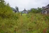 Visitors on Sept. 4, 2021, stroll by the historic chapel and buildings used for classrooms and dormitories that remain standing at Pilgrim Hot Springs. The site was used as an orphanage for B