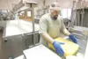 ROBERT DeBERRY/Frontiersman Matanuska Creamery Assistant General
Manager Matt Lewis prepares a 20-pound block of cheddar cheese for
packaging Thursday.