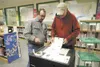 Election worker Lyle Gagos, left, mans the electronic ballot
machine at Larson Elementary during Tuesday's election. (ROBERT
DeBERRY/Frontiersman)