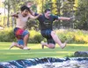 Japanese exchange student Shion Houri, left, and Palmer Junior Middle School student Trent Callis leap into a pond at the Hushower house in the Butte at a sister city barbecue on Saturday. CA