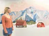 Palmer High IB artist Charlotte Pericht stands beside her mural depicting Sean Niekamp’s family farm. Niekamp is a graduate of Palmer High, and now a teacher at the school. Russell Clark/For 