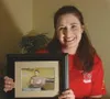 Sarah Burdan holds a framed photograph of her husband, Sgt.
David Burdan, who is a combat medic with the 411th Engineer
Battalion. BOB MARTINSON/Frontiersman
