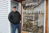 Jason Gardner stands in front of a custom-made sign.