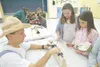 Sherrod Elementary School physical education teacher Lyle Busbey
helps McKayla Williams, 9, and Mikayla Merigan, 8, weigh a potato
Friday afternoon. Students at the school are growing the roo