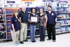 Sales associate Leisa Powell, Mat-Su Food Coalition President Don Houk, Walmart Manager Marlene Munsell, Blood N Fire Executive Director Karey Gaston, and associate Josh Sandrock pose for a p