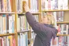 ROBERT DeBERRY/Frontiersman Palmer resident Kirsten Nelson looks
for a book at the Wasilla Public Library Thursday morning. The
library has temporarily suspended the purchase of new material 