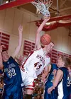 Wasilla 7-foot center Ray Schafer dunks the ball over the heads
of Palmer forward Kurtis Devon and Moose guard Dustin Dubois during
the first quarter of Wasilla's 44-35 win over Valley rival 