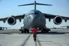 Airman 1st Class Zacheri Halla, 8th Expeditionary Air Mobility Squadron crew chief, marshals a C-17 Globemaster III assigned to Joint Base Lewis-McChord, Washington, while it taxis onto the r