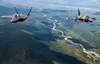A U.S. Air Force F-22 Raptor from Joint Base Elmendorf-Richardson and an F-16 Fighting Falcon from Eielson Air Force Base fly in formation over the Joint Pacific Alaska Range Complex, July 18