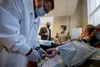 Frank Wake,, left, works with Covid-19 survivor, Karen Conley to draw convalescent plasma through a process called plasmapheresis. Apheresis nurse Steve Christodoulou, right, explains the pro