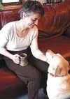 Claire Tallman communes with Blondie, a rescued yellow Lab who
shares the Tallman family with twelve retired sled dogs. Photo by
MARY SPEARS/Frontiersman.