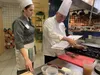 Culinary Institute of America San Antonio Chef Will Packwood and Gabriela Irwin, a chef at Spangdahlem Air Base, Germany, look over a pork loin recipe during the practical portion of the firs