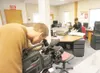 ROBERT DeBERRY/Frontiersman Anchorage freelance videographer Tom
Trainor films the archive books at the Mat-Su Valley Frontiersman
office as CNN field producer Jen Christensen searches throug
