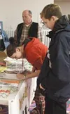 Wasilla Middle Schooler Amber Beasley signs a pledge not to
smoke as Zach Pierwola looks on. The teens bowled for half price as
part of BreatheFREE Mat-Su and North Bowl's smoke-free event la