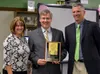 From left, Mat-Su Borough Superintendent Monica Goyette, Bob Williams and Colony High School principal Brendon McMahon pose with Williams’ plaque from the National Teachers Hall of Fame. Will