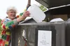 Mid-Valley Recycling volunteer, Jo Walch, deposits plastic jugs in the recycling bin at Big Lake Transfer Site. Plastic bottles, mixed paper, newspaper, metal and aluminum cans and corrugated