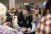 Three-time Iditarod champion Dallas Seavey signs a poster for a fan at the Iditarod mushers banquet at the Dena'ina Center in Anchorage on Thursday evening, where mushers drew bibs for the Sa