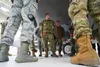 Senior Airman Issiah Alcaide, a native of Brooklyn, center, smiles while talking with fellow 90th Aircraft Maintenance Unit Airmen after a timed F-22 Raptor load crew competition on Joint Bas