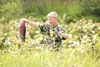 ROBERT DeBERRY/Frontiersman Tim Wood, 14, walks through the tall
grass along the edge of Cottonwood Creek carrying a Sockeye Salmon
he snagged Thursday afternoon.