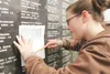 ROBERT DeBERRY/Frontiersman Sarah Tucker copies the name of her
brother, John Tucker, off the Veterans Wall of Honor Monday
afternoon after the Memorial Day ceremony.