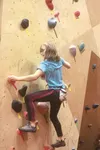 Piper Hancock works to complete the climb designated by pink tape without the assitance of ropes or harness during this weekend's Boulder Bash at Rock-On Climbing in Wasilla. Hancock placed n