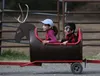 Avabella and Colby Cooney, 8 and 5 years old, take a spin around the Williams Reindeer Farm on the reindeer train during Great Land Trust's 'We Bought the Butte!' party on Thursday, June 2. C